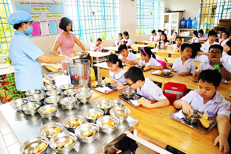 Công việc của bảo mẫu tại trường tiểu học chính là chăm lo cho trẻ bữa ăn bán trú